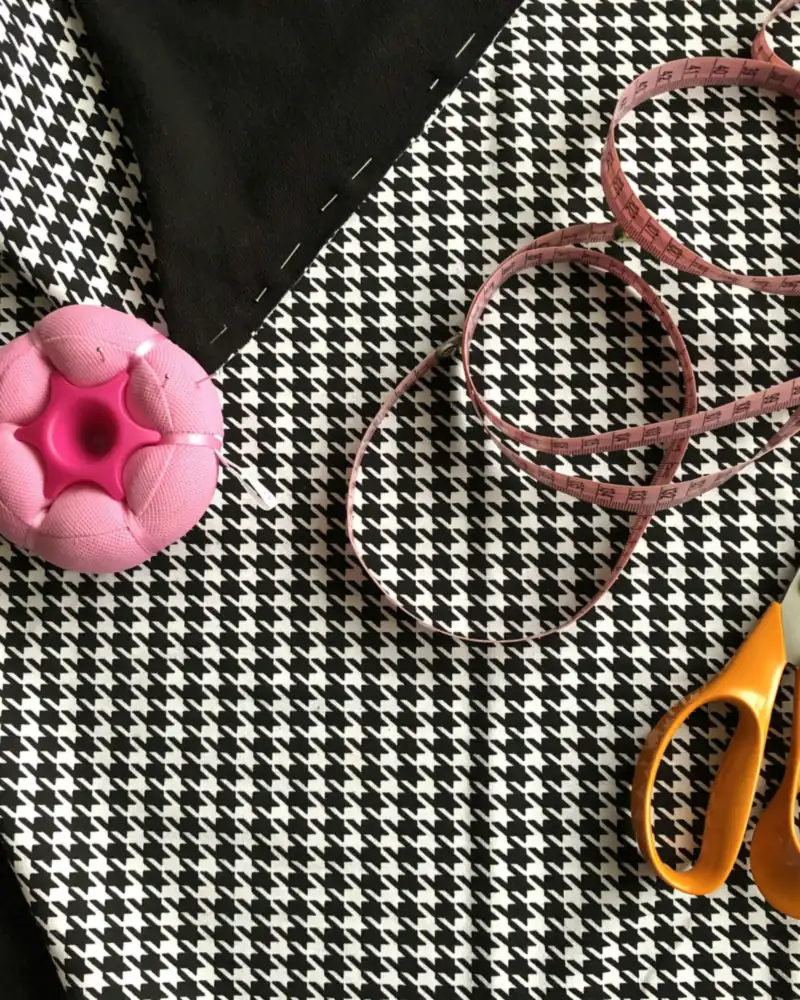 Houndstooth fabric with a tape measure, scissors and a pincushion