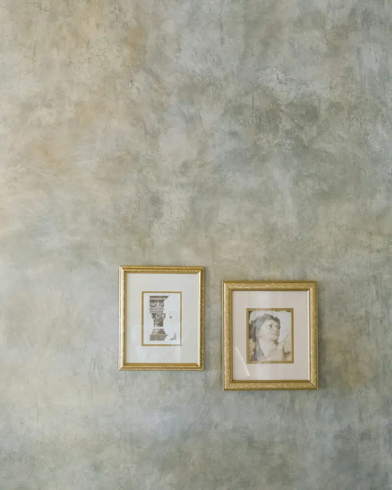 Grey-green marmorino wall with two small framed prints