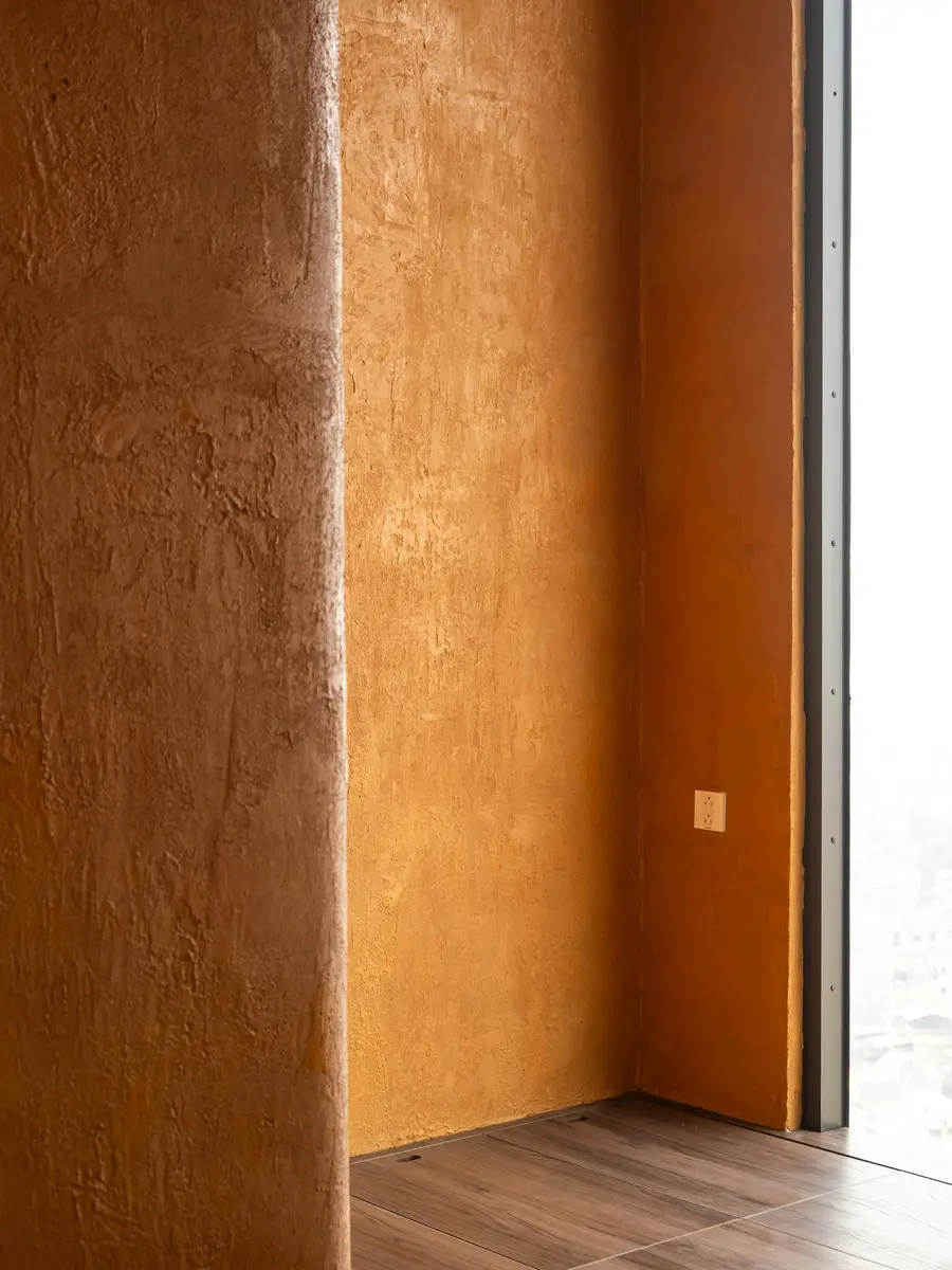 Warm ochre polished plaster on the walls of a narrow hallway